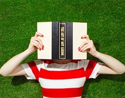 Person in Red Striped Shirt Laying Down with A Book On The Face