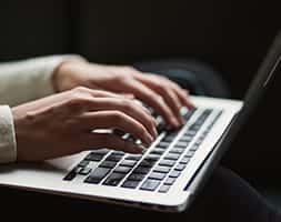Close Up View of A Person Typing On A Laptop