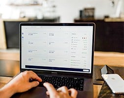 Person Working with Laptop and A Smart Phone on The Table