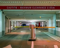 Car Park Entry with Caution Sign and Boom Gates