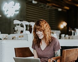 Smiling Woman in the Cafe with Her Laptop
