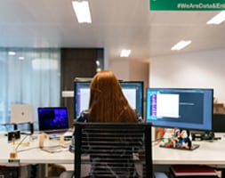 Woman Working At the Office Facing Two Monitors