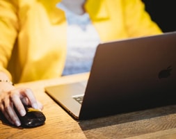 Lady in Yellow Coat Facing A Laptop