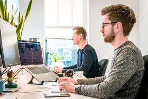 Two Men Working Facing Computer Screen
