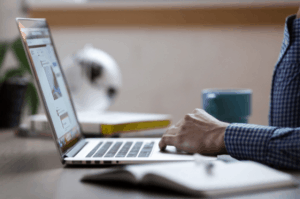 Man In Checkered Sleeve Using Laptop