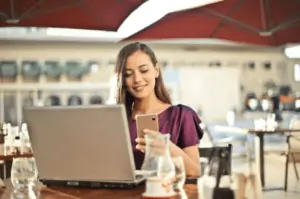 A Woman Holding A Smartphone While Sitting