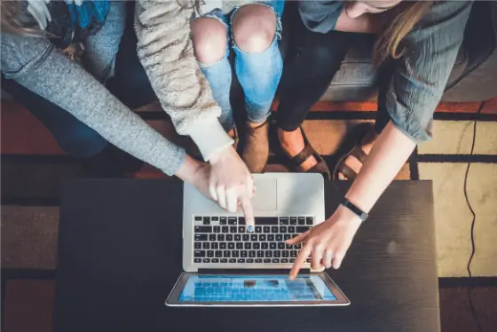 Three Persons Pointing At the Laptop Screen