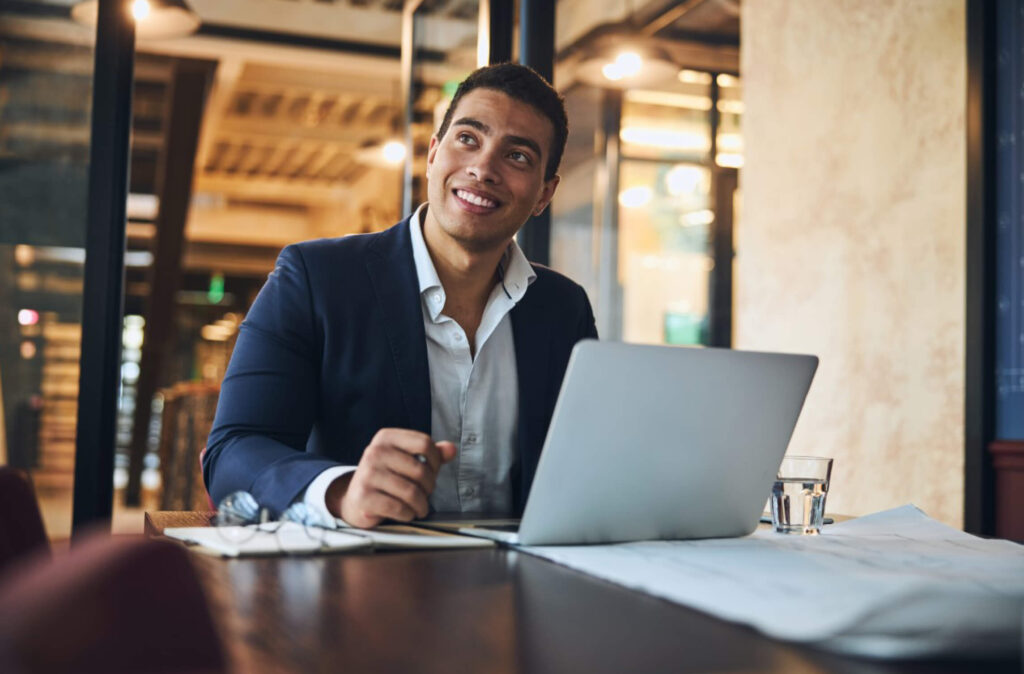 Smiling Man in A Business Suit with His Laptop