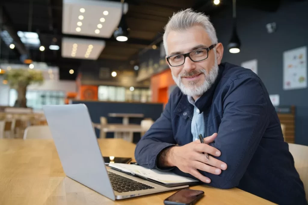 Man Facing The Camera With Laptop at the Front