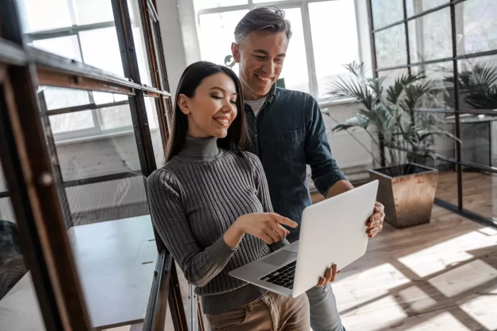 Smiling Man and Woman Looking at the Laptop