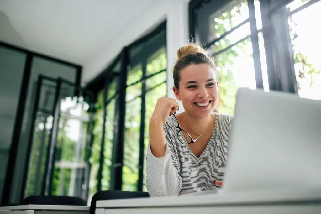 Smiling Woman in stripes Facing Her Laptop