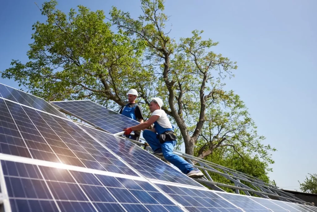 Two Men Installing Solar Panels at the Roof