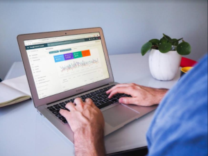 A man working with a laptop showing Google Analytics dashboard