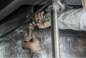 A close-up of a plumber’s hand installing pipe fittings