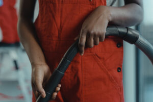A close-up of a person’s hand holding a vacuum hose