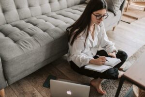Woman Sitting on The Floor Taking Notes
