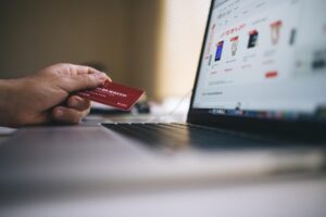Person Holding A Credit Card While Browsing In An Online Shop