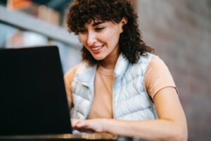 Smiling Woman Typing on the Laptop