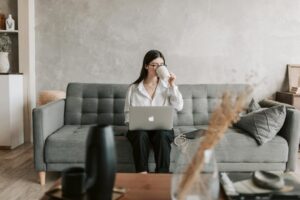 Working Lady In Front Of A Laptop Sipping Coffee